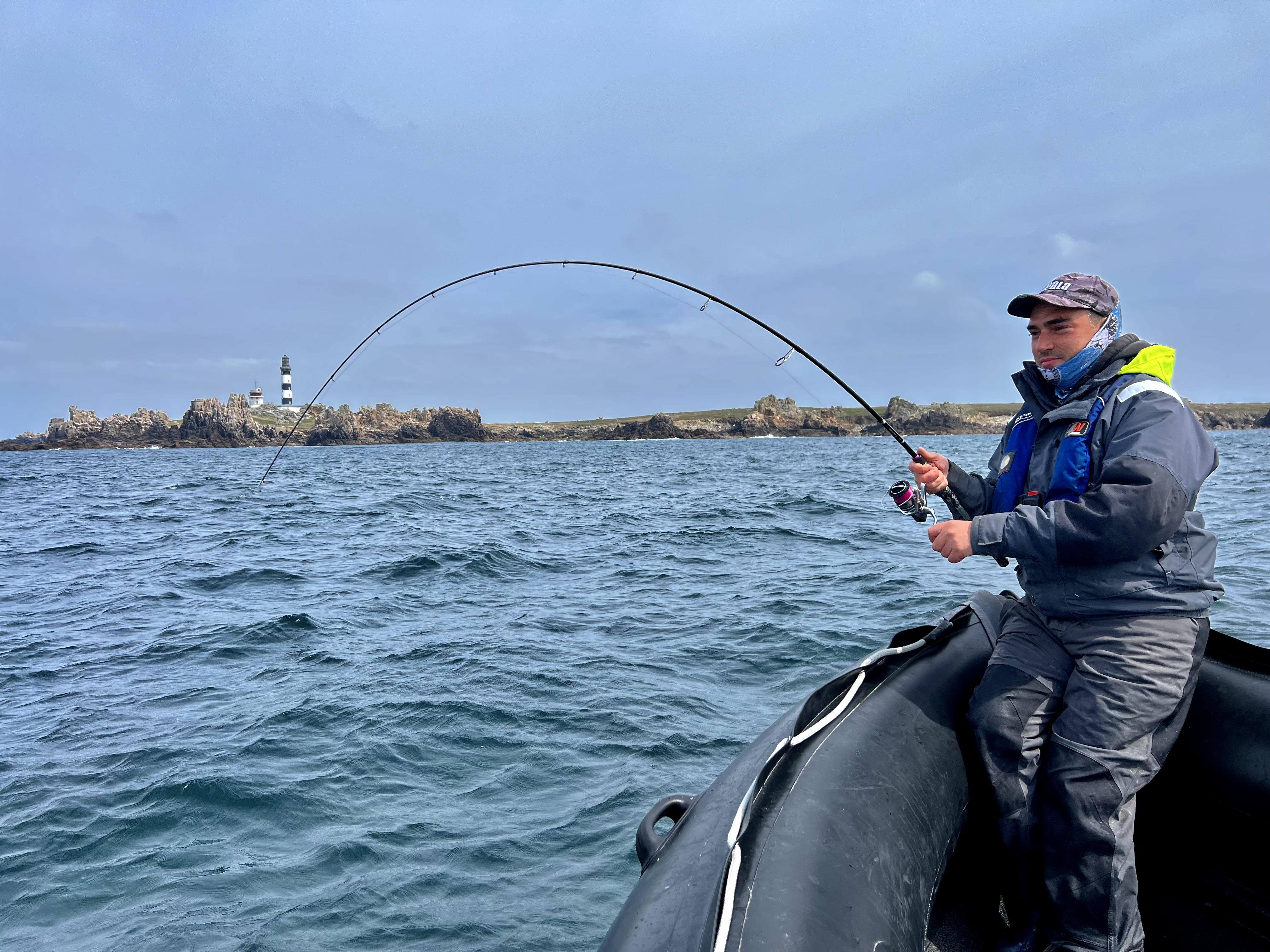 Pêcheur à la ligne avec poisson au bout de la ligne 